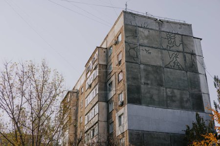 Antiguo edificio residencial soviético de varios pisos en color gris. Casa de panel con balcones