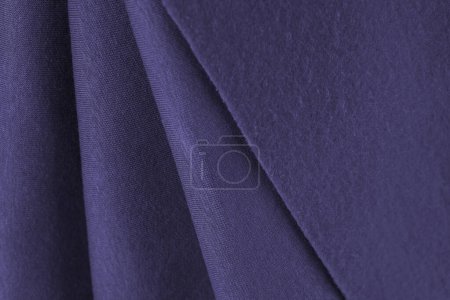Schichten aus französischem Frottee-Flieder, dunkelviolett, violett, charoitfarbenem Stoff. Schnitt zum Nähen, Fuß warmes Textil, Textur Hintergrund. Kleiderkreation, Auswahl im Stoffladen