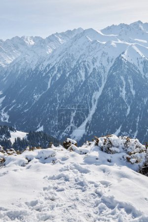 Path in the snow, up to a point where there is a view of a high mountain valley with snow-capped peaks. Karakol ski resort. Winter scenery wallpaper. Kyrgyzstan, Kyrgyz Republic, Kirghizia