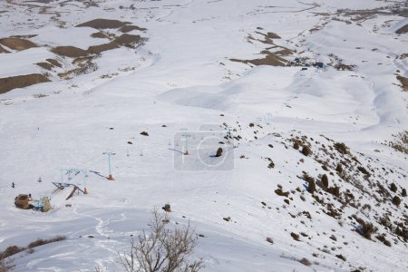 Natural landscape, mountain slope. Active leisure, winter sports. Cableway for skiers and snowboarders. Toguz Bulak ski resort in Kyrgyzstan. 