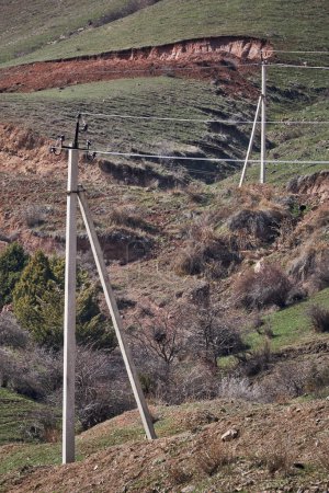 Old power line with small power flows at low household voltage levels in the countryside. electric transmission, two concrete pillar, carrying electricity to remote areas. Electrical wiring networks