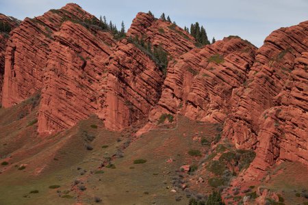 Rocas rojas siete bueyes, árboles de coníferas en la cima de la roca, 7 toros, garganta Jety-Oguz. Ubicación del turismo, lugar de destino turístico, Kirguistán hito Jeti Oguz. Acantilado de arenisca, senderismo, paisaje natural