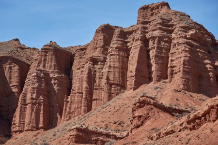 Sheer cliffs subject to erosion, red rocks of the Konorchek canyon, travel destination, famous landmark Kyrgyzstan, Central Asia. Rock formation, natural landscape, hiking trekking area, sandstone