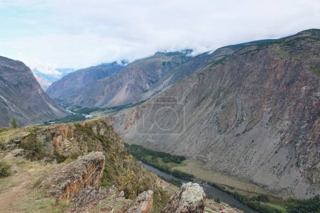 Vue du col Katu-Yaryk à la vallée de Chulyshman. De hautes montagnes, une rivière et au-dessous. Saison estivale dans les montagnes Altaï