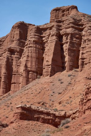 Felsige Säulen aus rotem Sandstein in der Konorchek-Schlucht, äolische Ablagerungen, schiere Klippen als Ergebnis der Bodenerosion. Verwitterung und Auswaschen von Gesteinsformationen. Reiseziel, berühmtes Wahrzeichen Kirgisistans