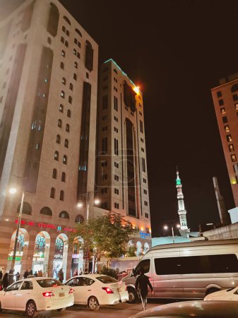 Photo for MEDINA, SAUDI ARABIA- DEC 31, 2022: Evening street view of hotels and streets near Masjid Nabawi Mosque in Al Madinah, Saudi Arabia.  Muted pastel color filter applied. - Royalty Free Image