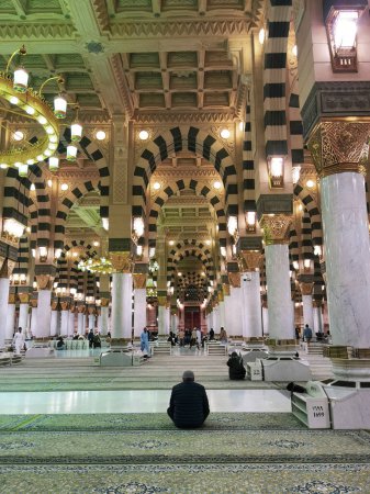 Photo for Unidentified Muslim man sits while waiting for the next prayer to start inside Masjid Al Nabawi  in Al Madinah, Saudi Arabia. - Royalty Free Image
