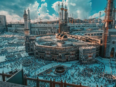 Photo for Exterior top view of work in progress Haram Grand Mosque with Muslim pilgrims walking on the compound in Mecca, Saudi Arabia. - Royalty Free Image