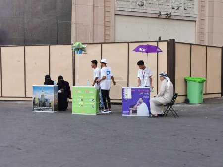 Photo for MECCA, KINGDOM OF SAUDI ARABIA-JUNE 1, 2023 : Three Saudi Arabia telecommunication providers Mobily, Zain and STC man their kiosk for Muslim pilgrims communication needs in Makkah. - Royalty Free Image
