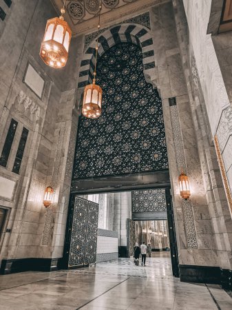 Photo for MECCA, KINGDOM OF SAUDI ARABIA-JUNE 1, 2023 : A Muslim couple walks under huge door at the new King Abdullah extension in Makkah, Saudi Arabia. The new extension expected to cost USD30 billion. - Royalty Free Image
