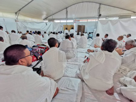 Téléchargez les photos : 27 JUIN 2023-PLAINE D'ARAFAT, MINA, ARABIE SAOUDITE : Les pèlerins du hajj de Malaisie en vêtements blancs d'ihram attendent la prière de l'après-midi (salah) à la Plaine d'Arafat à Mina, La Mecque, Royaume d'Arabie Saoudite. - en image libre de droit