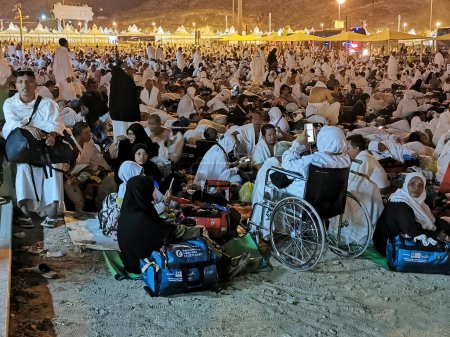 Téléchargez les photos : 27 JUIN 2023-MUZDALIFAH, MINA, ARABIE SAOUDITE : Des pèlerins du hajj de Malaisie en vêtements blancs d'ihram attendent leur bus à Muzdalifah, La Mecque, Royaume d'Arabie Saoudite. - en image libre de droit