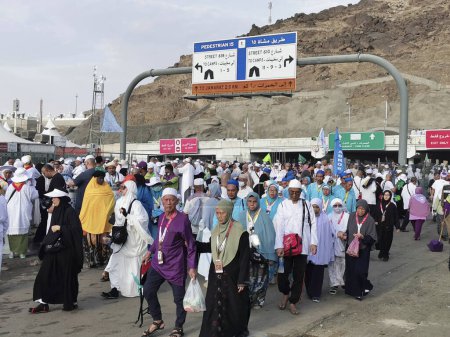 Photo for MINA, KINDOM OF SAUDI ARABIA (KSA)-JUNE 30, 2023 : Asian Muslim hajj pilgrims walk to their camp after performing stoning devils rituals in Mina, Saudi Arabia. - Royalty Free Image