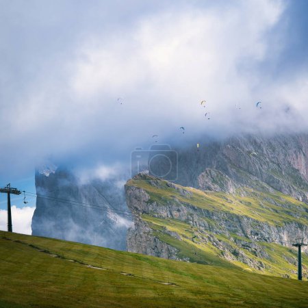 Eine Gruppe Gleitschirmflieger über dem Seceda in den Dolomiten, Italien