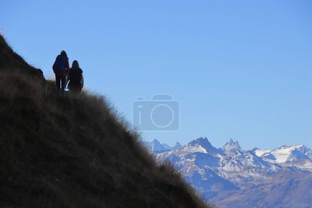 Photo for Panoramic hiking trail from Torrent Rinderhtte to Wysse See. Two hikers at the horizon, mountains in the background. - Royalty Free Image