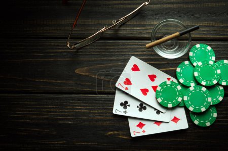 Foto de Juego de póquer con tres de una combinación ganadora tipo. Tarjetas con fichas en una mesa negra en un club de poker. - Imagen libre de derechos