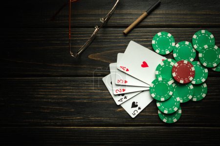 Foto de Jugar al póquer con una combinación ganadora de cartas altas. Tarjetas con fichas en una mesa vintage negra en un club de poker. - Imagen libre de derechos