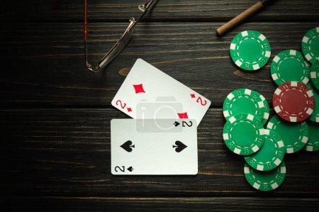 Foto de Jugar a las cartas con una combinación ganadora de un par y fichas en una mesa vintage negra en un club de póquer. Espacio de copia para publicidad - Imagen libre de derechos