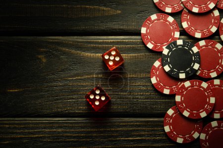 Dados de póquer en una mesa vintage negro y fichas de ganancias. Espacio libre para publicidad