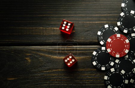 Foto de Dados de póquer en una mesa vintage negro y fichas de una victoria afortunada. Espacio libre para publicidad. - Imagen libre de derechos
