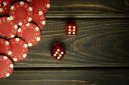 Foto de Dados de póquer con una combinación ganadora en una mesa vintage negra y fichas de una apuesta afortunada. Espacio libre para publicidad - Imagen libre de derechos
