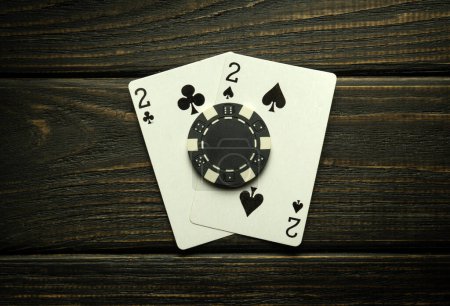 Foto de Juego de póquer con una combinación de pares. Fichas y cartas en la mesa vintage negro en el club de póquer. Espacio publicitario gratuito. - Imagen libre de derechos
