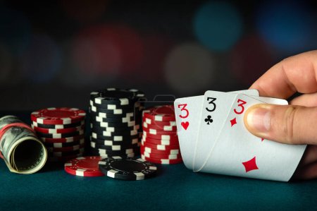 Photo for Poker cards with three of a kind or a set combination. The player hand holds a winning combination in a game in a poker club - Royalty Free Image