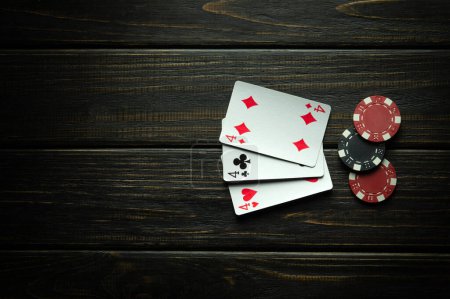 Foto de Juego de póquer de juego con tres de una combinación ganadora tipo. Tarjetas con fichas en una mesa negra en un club de poker. Espacio libre para publicidad - Imagen libre de derechos