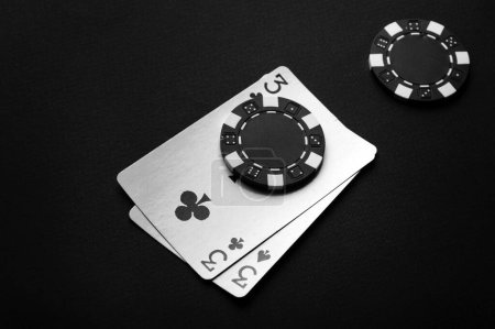 Foto de Un juego de póquer con una combinación ganadora de un par. Fichas y cartas en una mesa negra. - Imagen libre de derechos