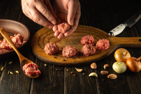 The chef hands form meatballs from ground beef. Concept of preparing a meat dish at brunch.