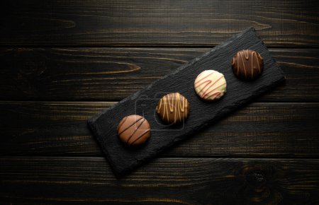 brownie au chocolat rond sur une planche de service noire. Délicieux concept de dessert sur table de cuisine sombre vintage.