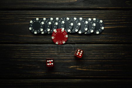 Very popular poker dice or Craps game on a dark vintage table and chips from a lucky win. Successful combination of two sixes in dice.