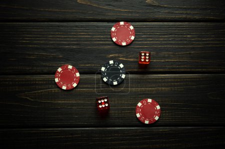 Dos dados y fichas ganadoras en una mesa de casino oscura. Una exitosa combinación de dos seises en los dados del juego.
