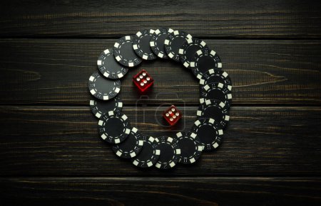 Low-Key-Konzept des Gewinnens in einem Pokerclub. Kombination aus zwei Sechsen in Würfeln und schwarzen Chips auf einem Vintage-Tisch. Glück im Würfelspiel.