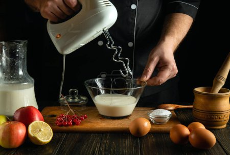 Professioneller Koch bereitet in der Küche ein kulinarisches Gericht mit Milch und Eiern zu. Kleines Konzept der Zubereitung eines köstlichen Mittagessens auf dem Küchentisch in einer Taverne.