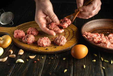 Pétrir les escalopes avec les mains d'un cuisinier sur la table de cuisine. Concept clé bas de la préparation d'un plat de viande pour le déjeuner.