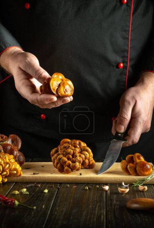 A professional chef prepares fresh Flammulina mushrooms in the hotel kitchen. The concept of preparing dietary wild mushrooms for lunch.