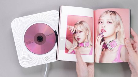 Photo for Fan hands holding BlackPink BORN PINK 2nd Album photobook with Rose on grey. Pink music CD in player. South Korean girl group BlackPink. Space for text. Gatineau, QC Canada - November 10 2022. - Royalty Free Image
