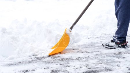Ein Mann schaufelt nach einem Wintersturm in Kanada Schnee von seiner Einfahrt. Mann mit Schneeschaufel reinigt Bürgersteige im Winter Winterzeit