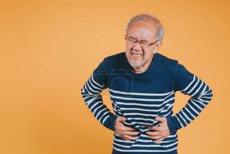 Photo for Asian Senior man feel stomachache. Older mature male touch belly. Bowel problem health care and medical insurance concept. - Royalty Free Image