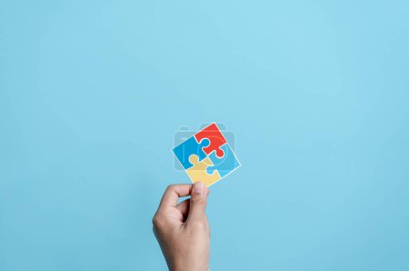 Photo for Hand holding Color puzzle symbol of awareness for autism spectrum disorder family support. Father, Mother, Children holding jigsaw puzzle Autism World Awareness Day. - Royalty Free Image