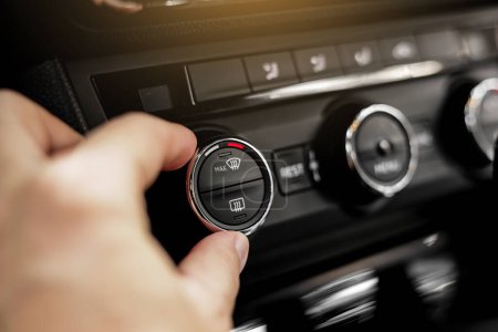 Photo for Closeup of hand adjusting the conditioner in a modern car. Dashboard with air flow, climate control and temperature button temperature button inside transport. Car HVAC System. Detail interior of car. - Royalty Free Image