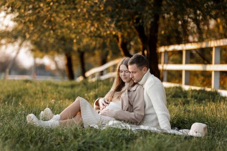 Photo for Mothers day. Stylish marriage pregnant couple waiting for baby. Man hugs and touches woman belly outdoors on plaid on grass. Family day. Pregnancy, parenthood, motherhood, love, family concept - Royalty Free Image