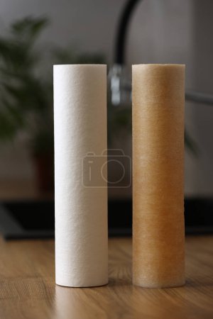 Photo for Water purification for domestic water supply. New clean and used water filter cartridge in rust on kitchen tabletop. Evidence of contamination of tap water with iron cations. House filtration. - Royalty Free Image
