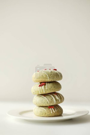 Close up of stack of homemade mint gingerbread cookies with matcha, decorated sublimated strawberries and vanilla cream on plate on white background. Sugar, gluten and lactose free and vegan