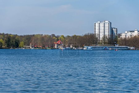 Téléchargez les photos : Berlin, Allemagne - 22 avril 2023 : Lake Tegeler Voyez avec la station de bateau sur le rivage Greenwichpromenade, bateau à passagers MS Havel Queen et Haven bridge (Sechserbruecke) - en image libre de droit