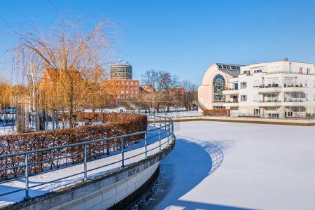 Téléchargez les photos : Berlin, Allemagne - 12 février 2021 : Bassin du port gelé Tegeler Hafen avec les bâtiments de la bibliothèque Humboldt et de la clinique Medical Park Humboldtmuehle - en image libre de droit