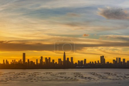 Foto de Panorama of silhouette of skyline of Shenzhen city, China at sunset. Viewed from Hong Kong border - Imagen libre de derechos