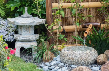 Téléchargez les photos : Lanterne en pierre et fontaine en bambou dans le jardin japonais - en image libre de droit