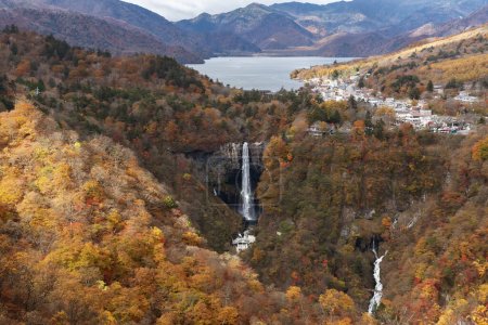 Téléchargez les photos : Paysage idyllique de la cascade de Kegon, qui tombe du lac Chuzenji dans une gorge, avec des couleurs d'automne brillantes sur les falaises rocheuses par une belle journée d'automne, dans le parc national Nikko, Tochigi, Japon - en image libre de droit